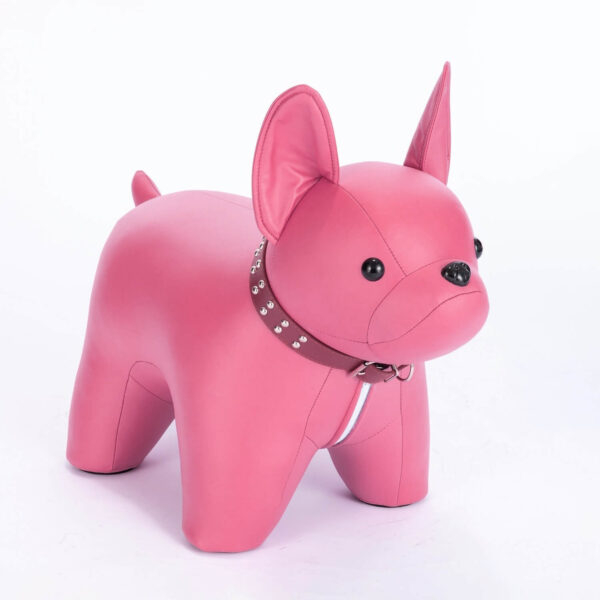 Half side shot of pink colored French Bulldog shaped stool, against white background.