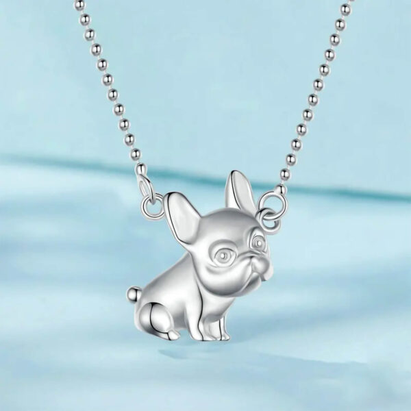 Product shot of the Silver French Bulldog Charm Necklace against pastel blue background