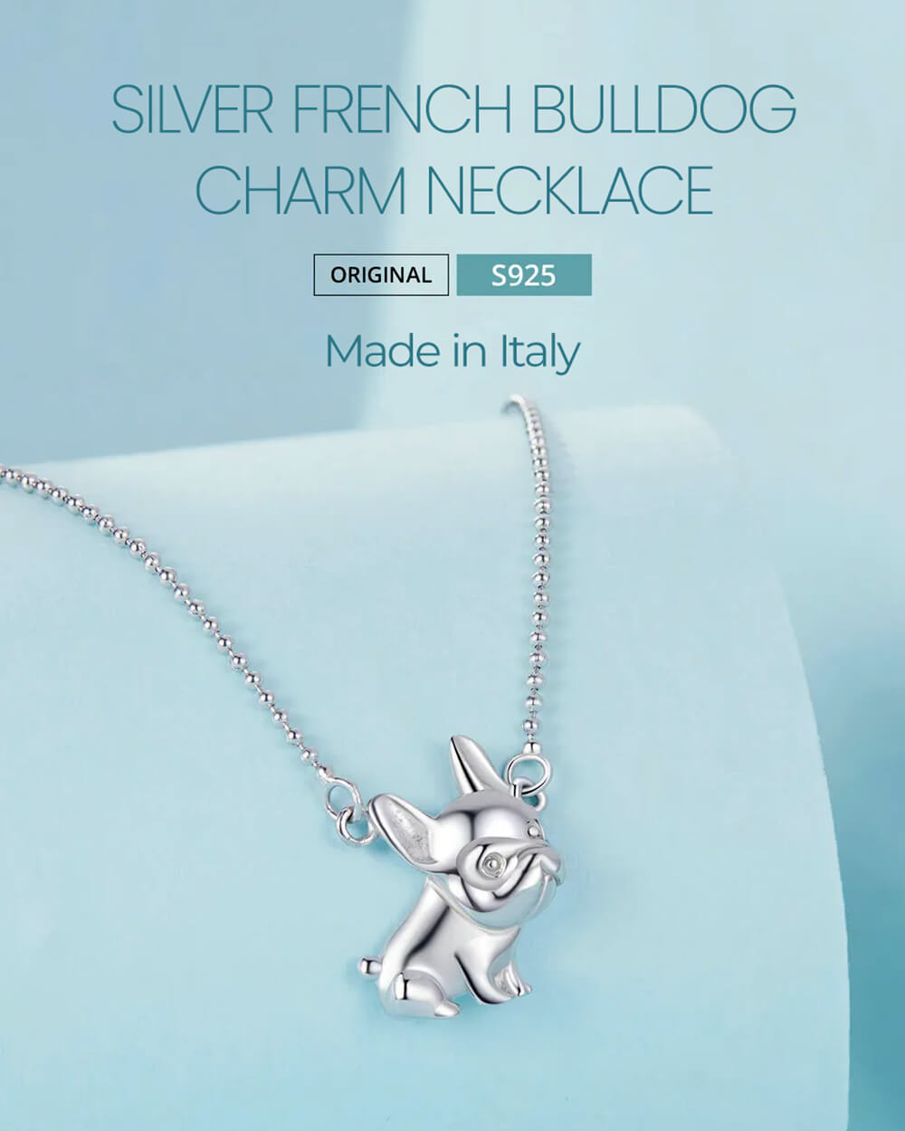 Product shot of the Silver French Bulldog Charm Necklace on the pastel blue product display