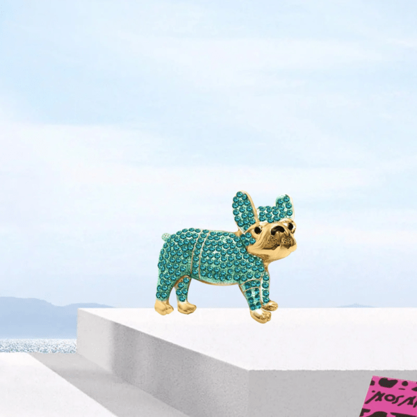 Emerald colored Iced Out French Bulldog Brooch on a marble product display